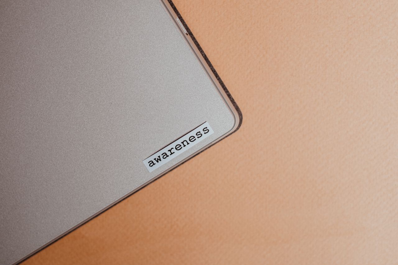 services-01 Close-up view of a beige laptop featuring an awareness sticker, encouraging mindfulness and better digital organization.